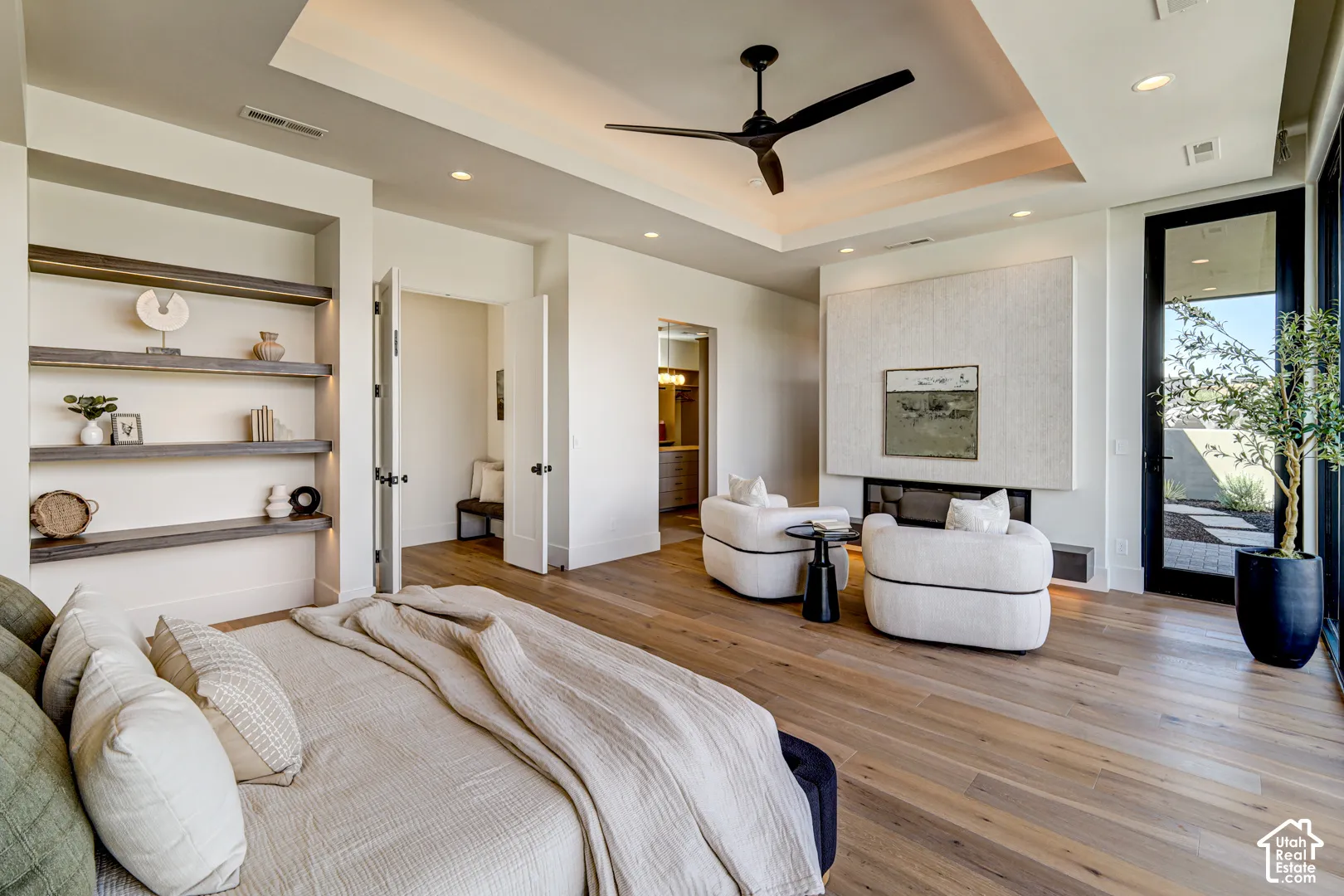 Wood-finish flooring, recessed lighting, and a tray ceiling with a modern ceiling fan
