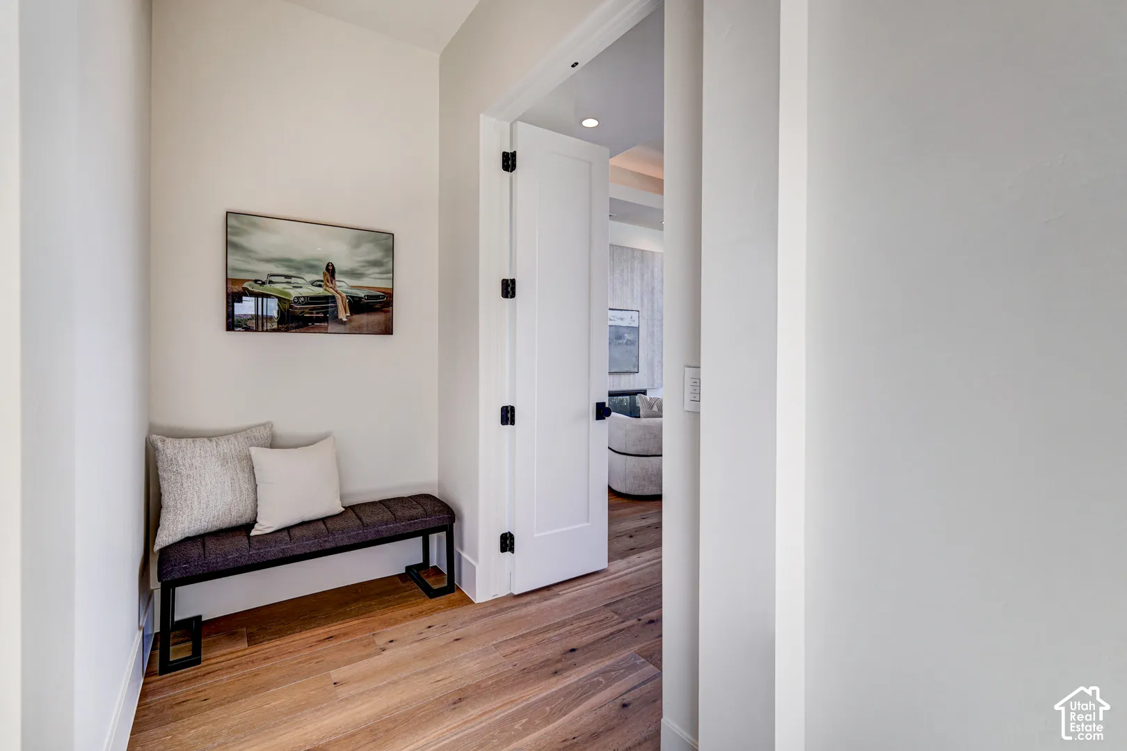 Hardwood flooring, crisp white walls, and a solid core door with matte black hardware