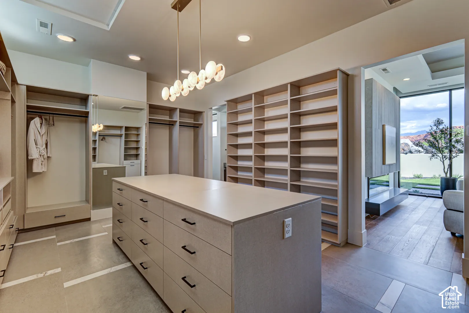 Built-in custom cabinetry, central island with drawers, extensive shelving, and recessed lighting
