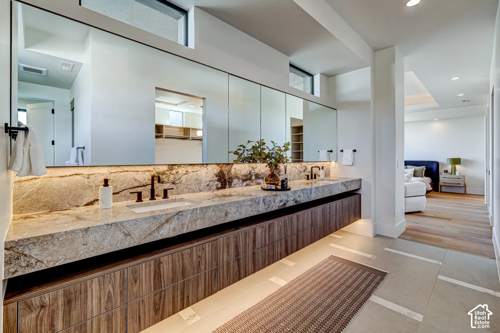 Floating dual vanity with stone countertop, integrated sinks, and wood-finish cabinetry