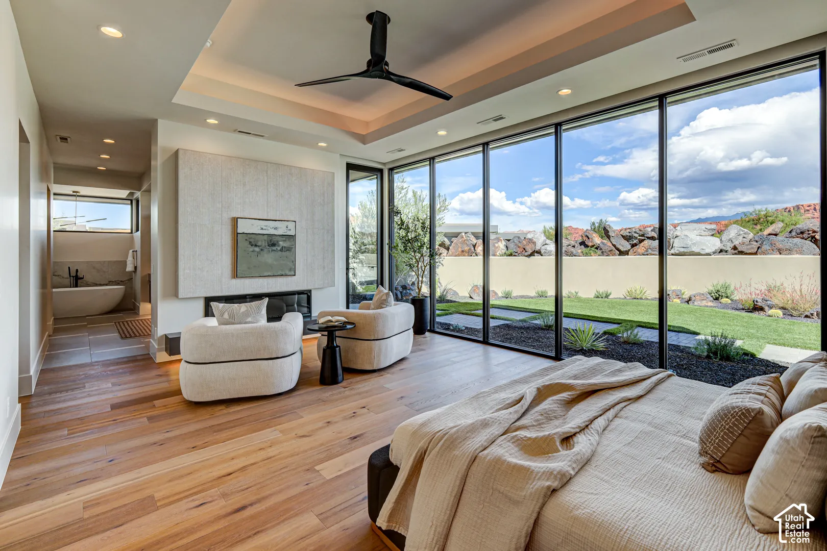 Hardwood-finish flooring, full-height windows, built-in fireplace, recessed lighting, and a tray ceiling