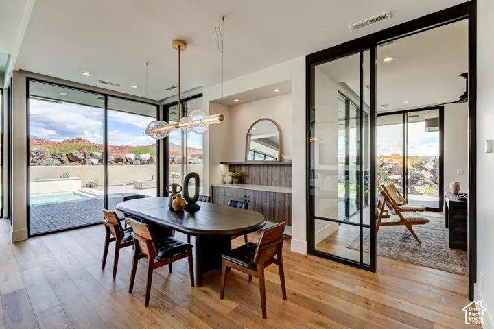 Wide plank wood-finish flooring, built-in cabinetry, large format sliding glass doors, built-in shelving, and recessed lighting