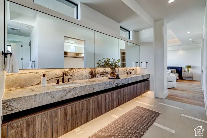 Floating dual vanity with stone countertop, integrated sinks, and wood-finish cabinetry