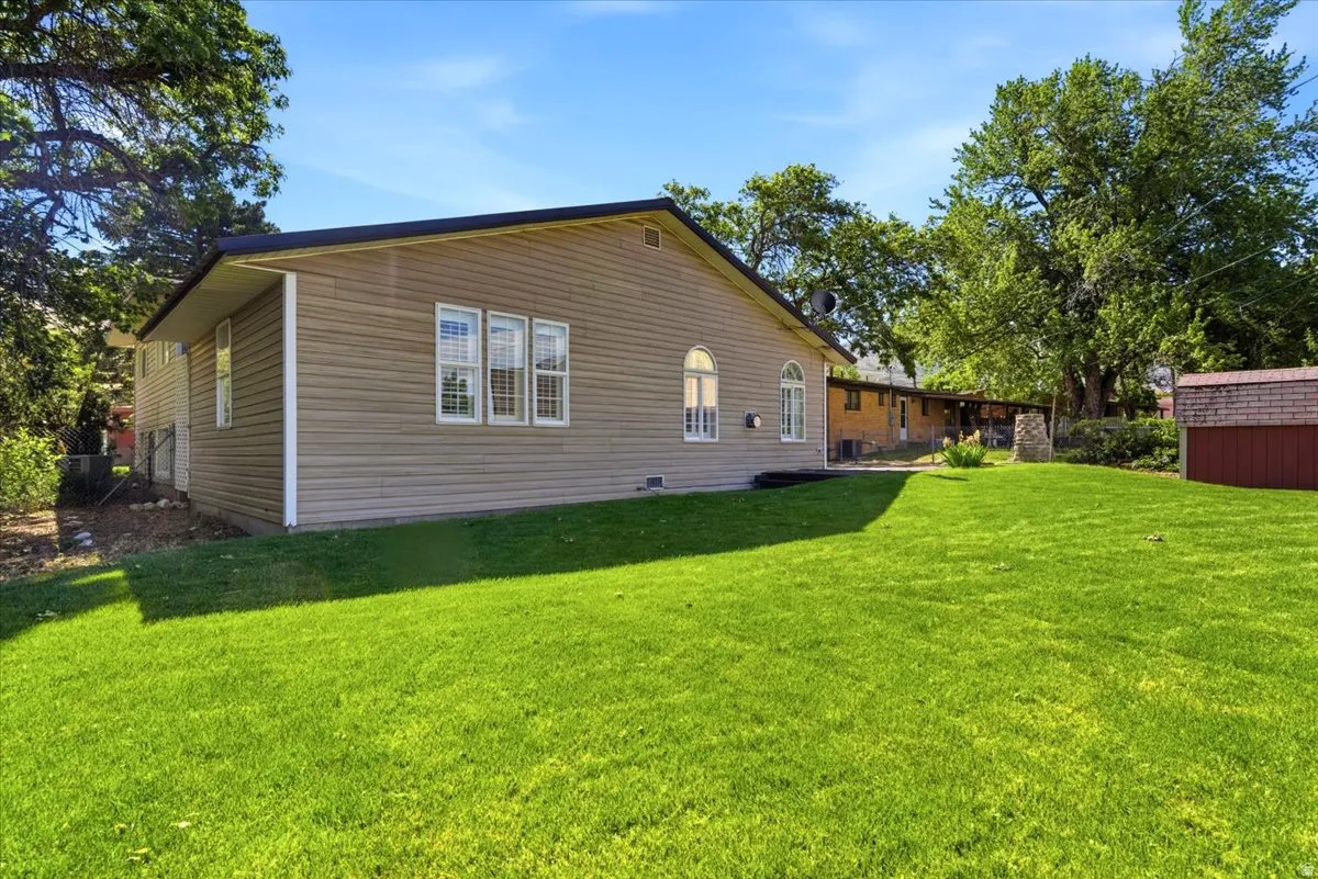 Expansive green lawn bordering the tan-sided property