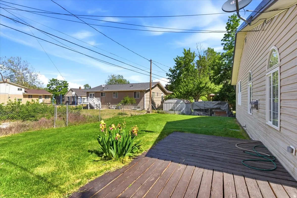 Expansive green lawn with a dark wood deck