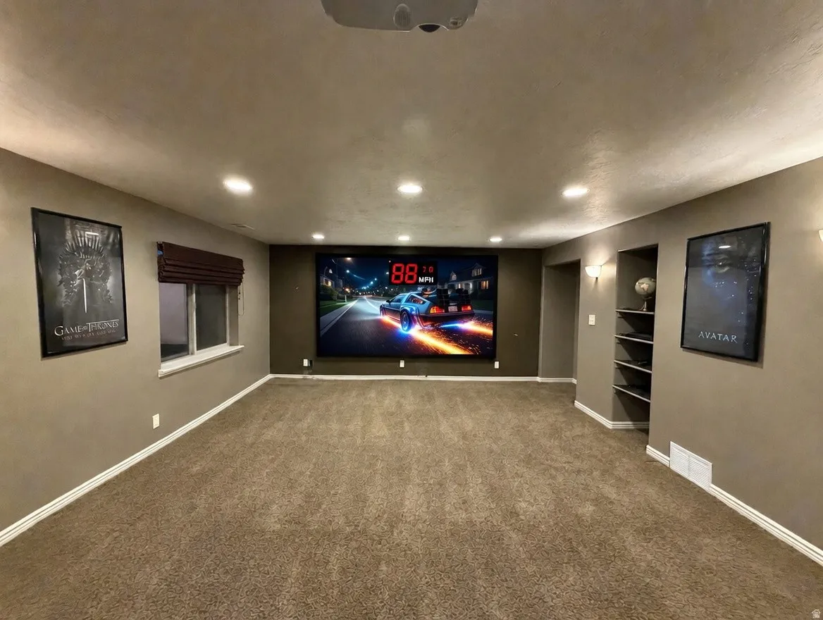 Dedicated media room featuring a large projection screen, recessed lighting, and soft carpet flooring