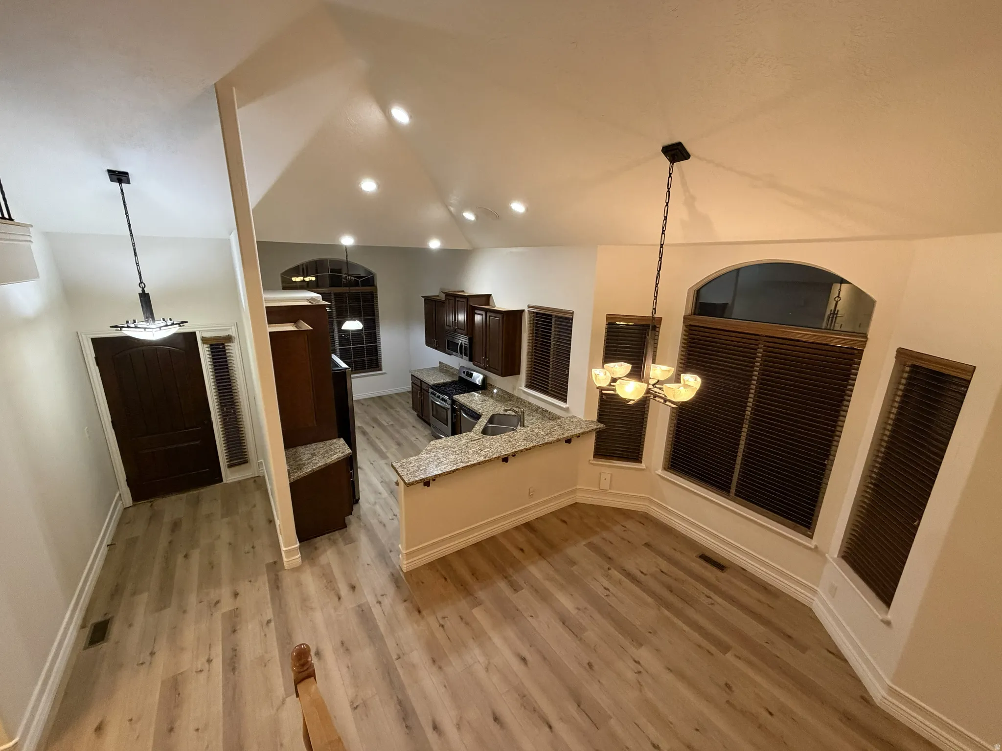 Vaulted ceilings and light wood-finish flooring characterize this open-concept space