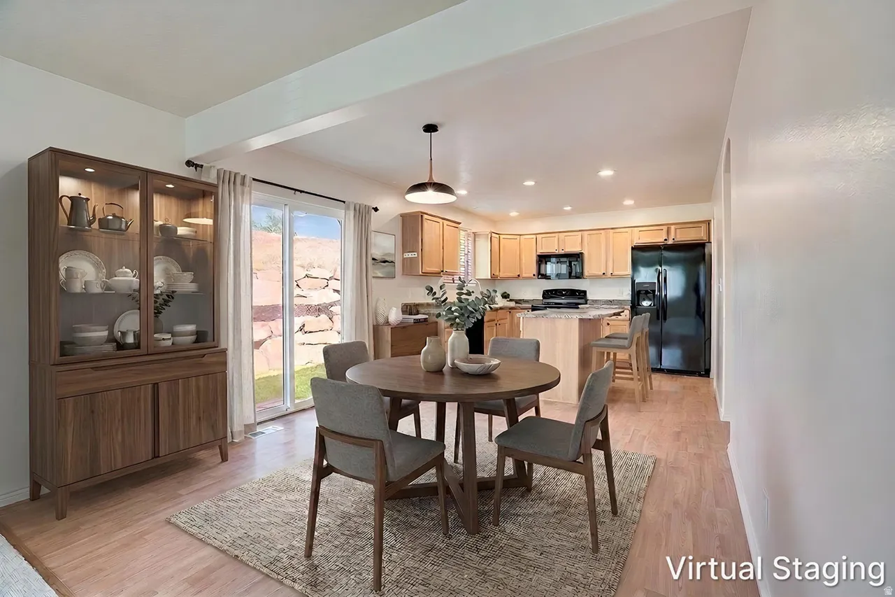 Open-concept dining area featuring wood-finish flooring, a contemporary pendant light fixture, and sliding glass doors leading to the exterior