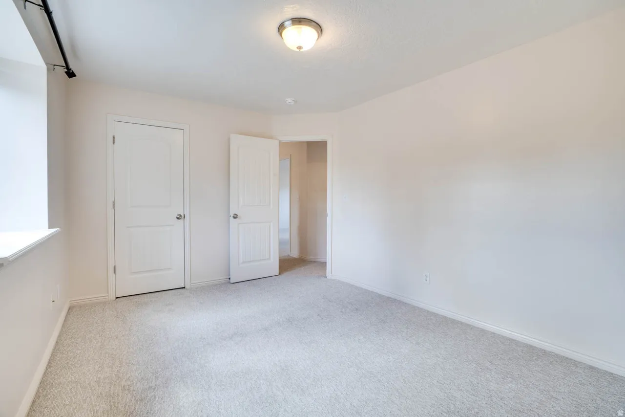 Neutral tone walls, light-colored carpeting, and white trim