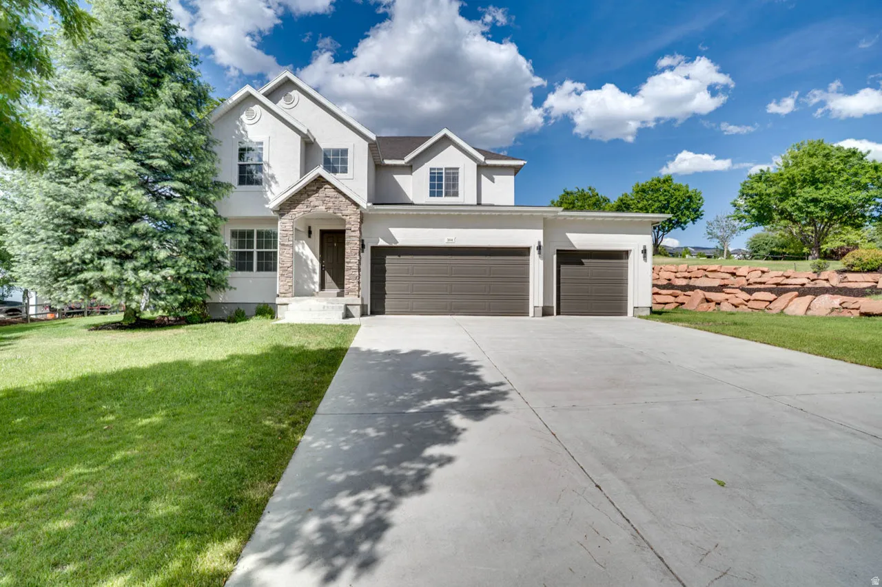 Two-story residence featuring a stucco exterior with stone accents and a covered entryway