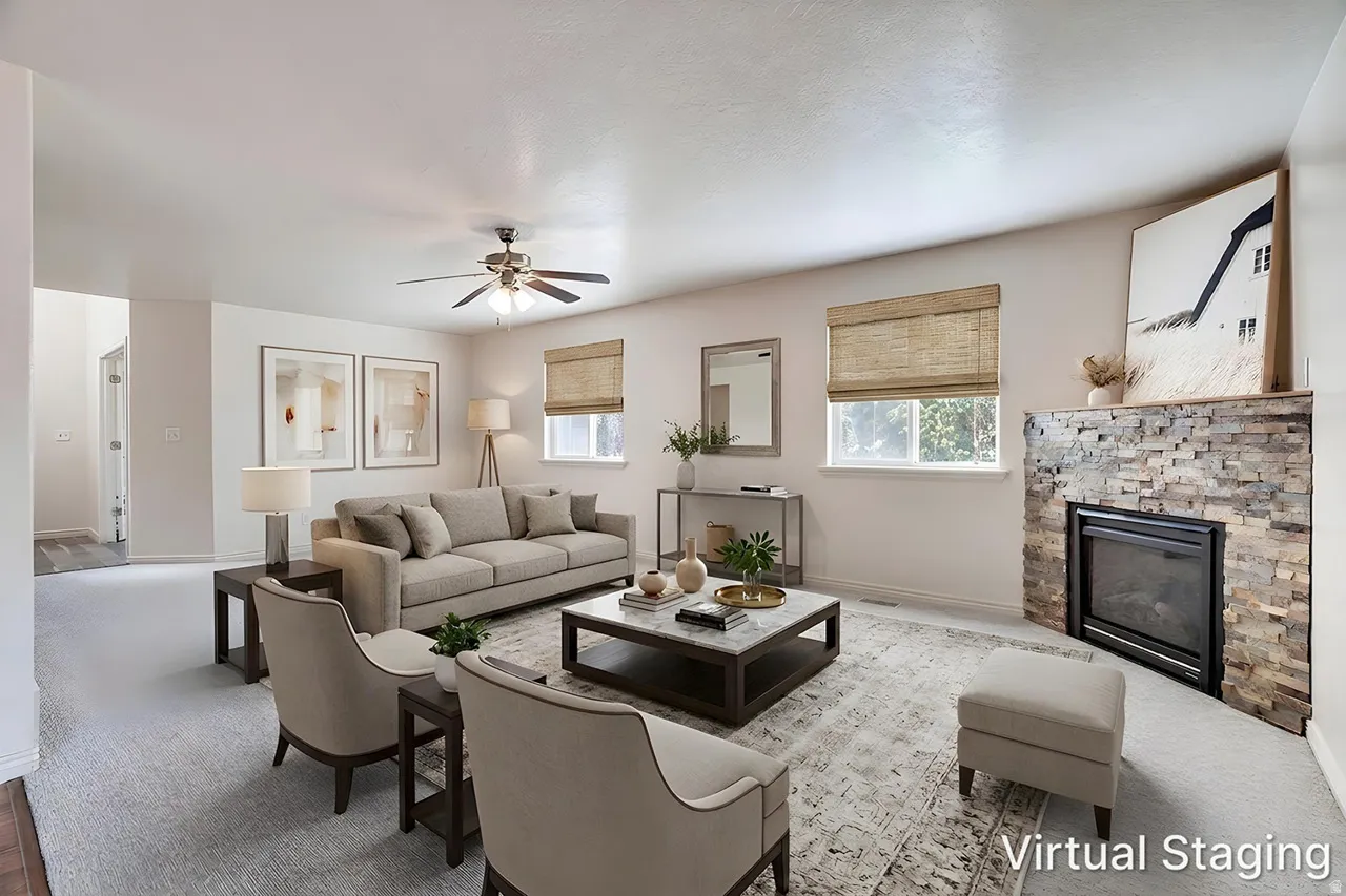 Spacious living area featuring a stone-clad fireplace with a built-in firebox, light-toned walls, and a ceiling fan