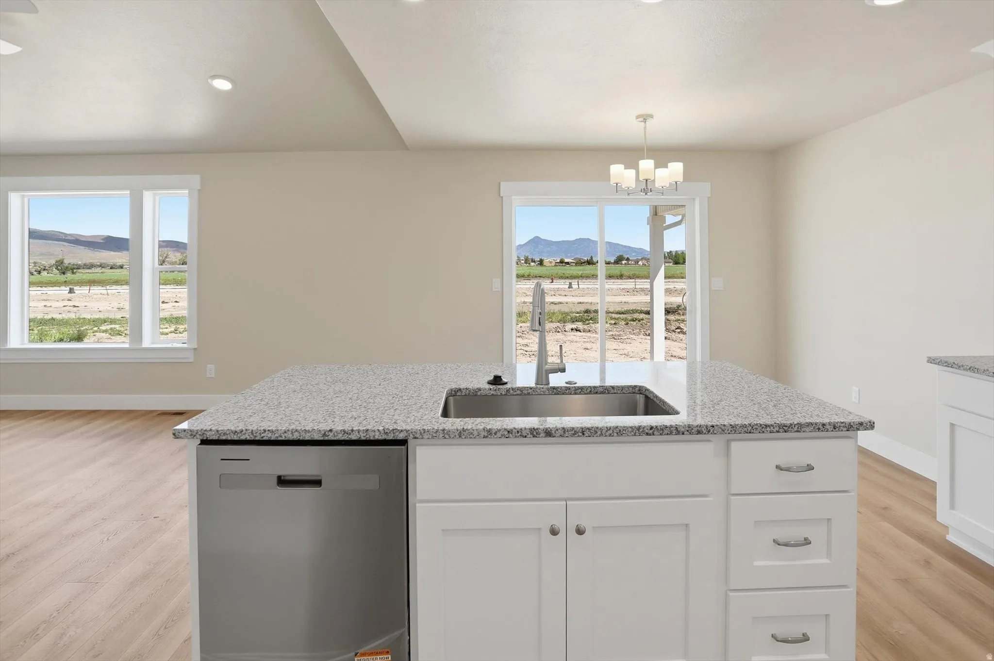 Kitchen island with a stainless steel sink, gooseneck faucet, and integrated dishwasher