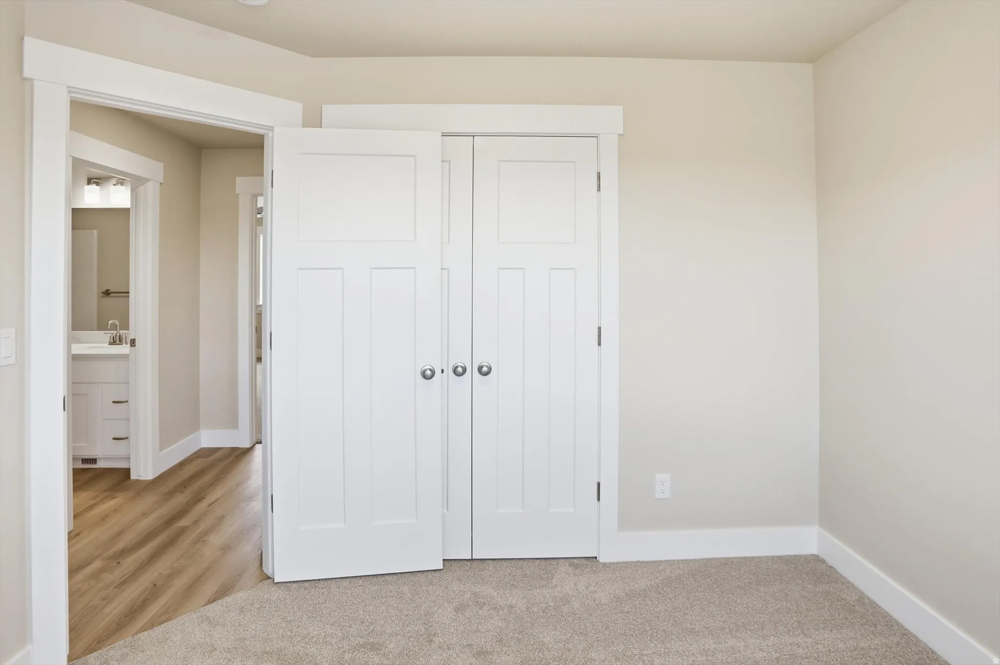 Double panel interior doors with brushed nickel hardware, light neutral wall color, and plush carpet flooring