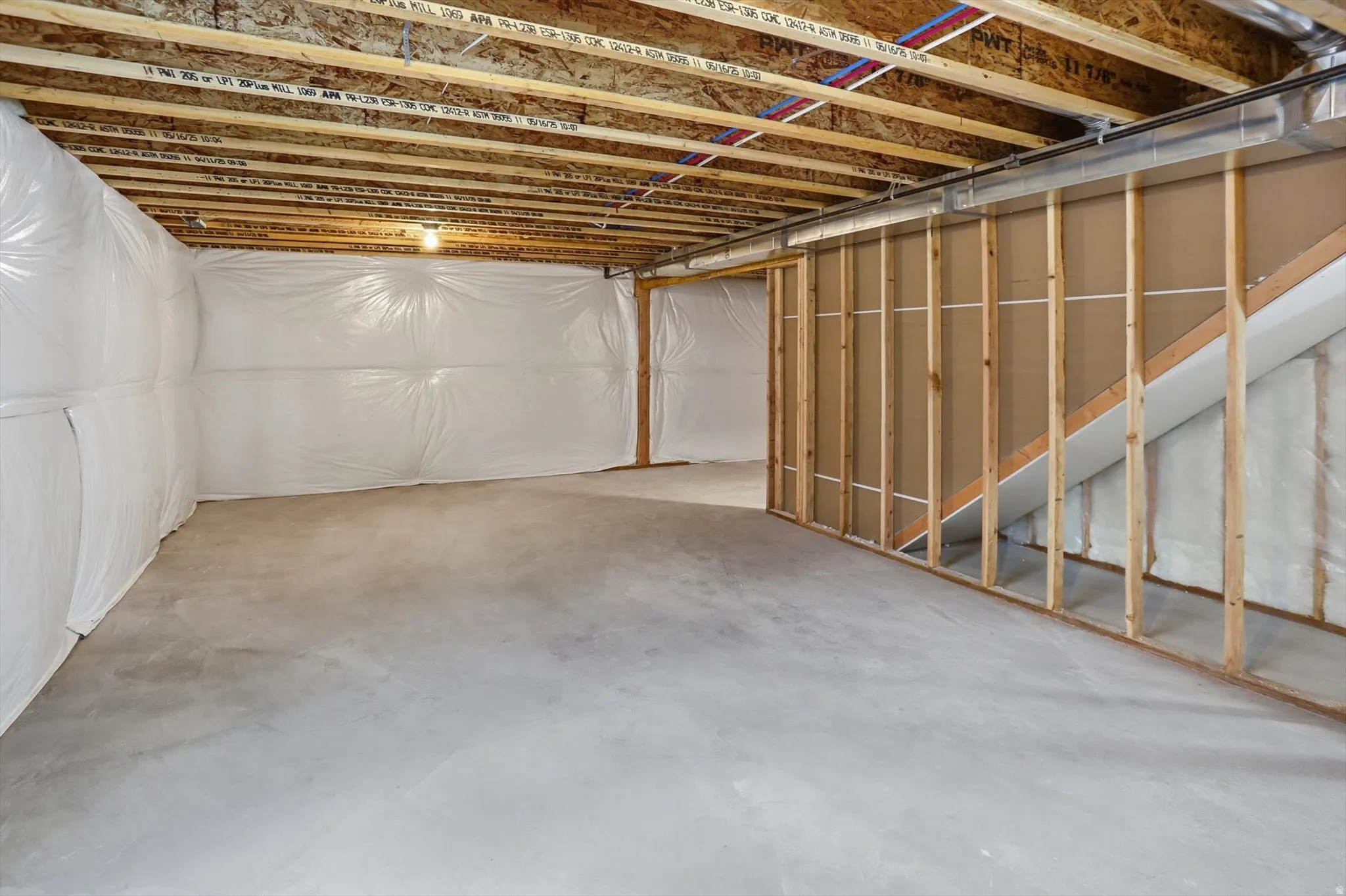 Unfinished basement with concrete flooring and exposed ceiling joists