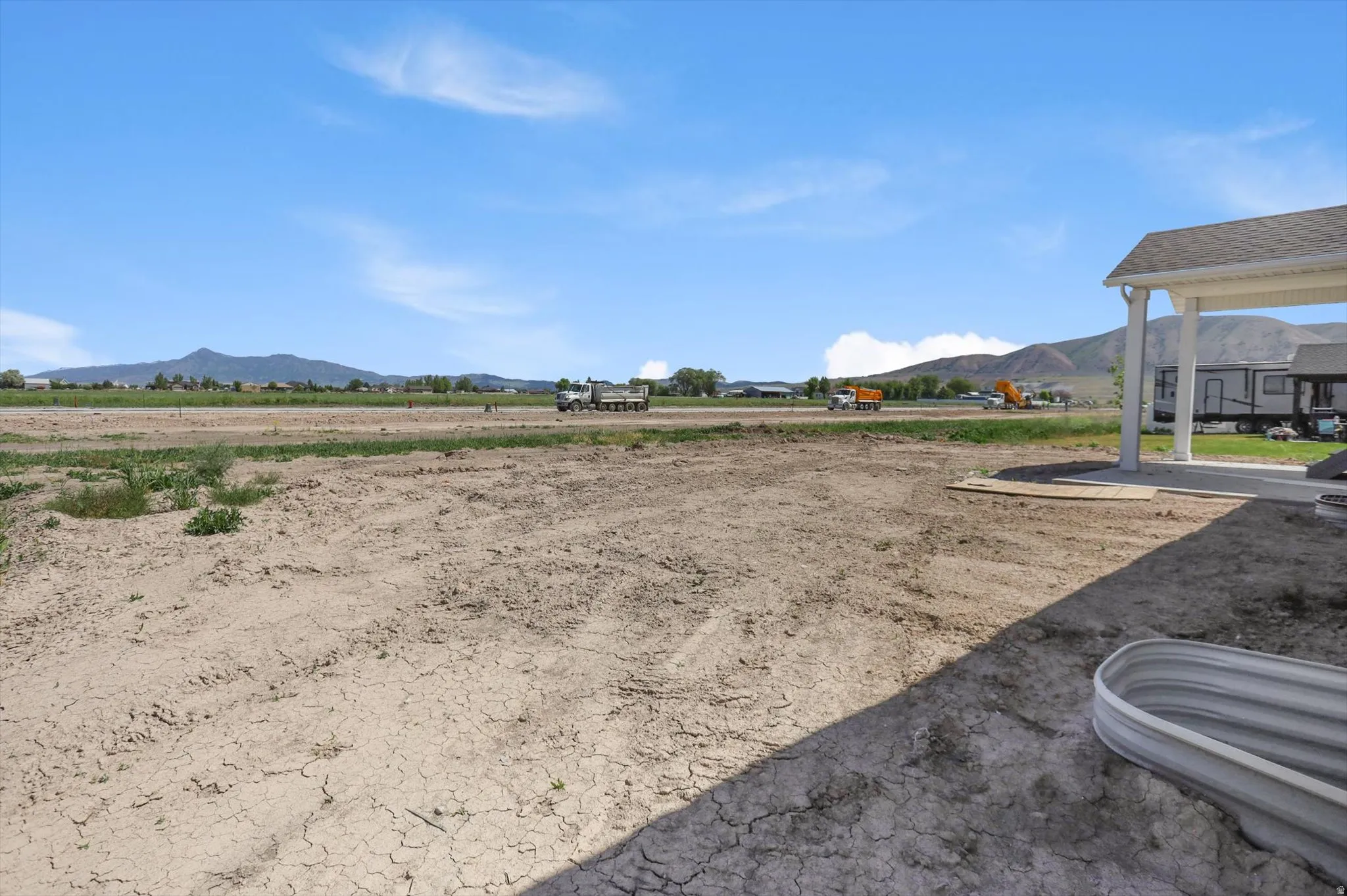Expansive undeveloped lot featuring mountain scenery and a covered patio structure