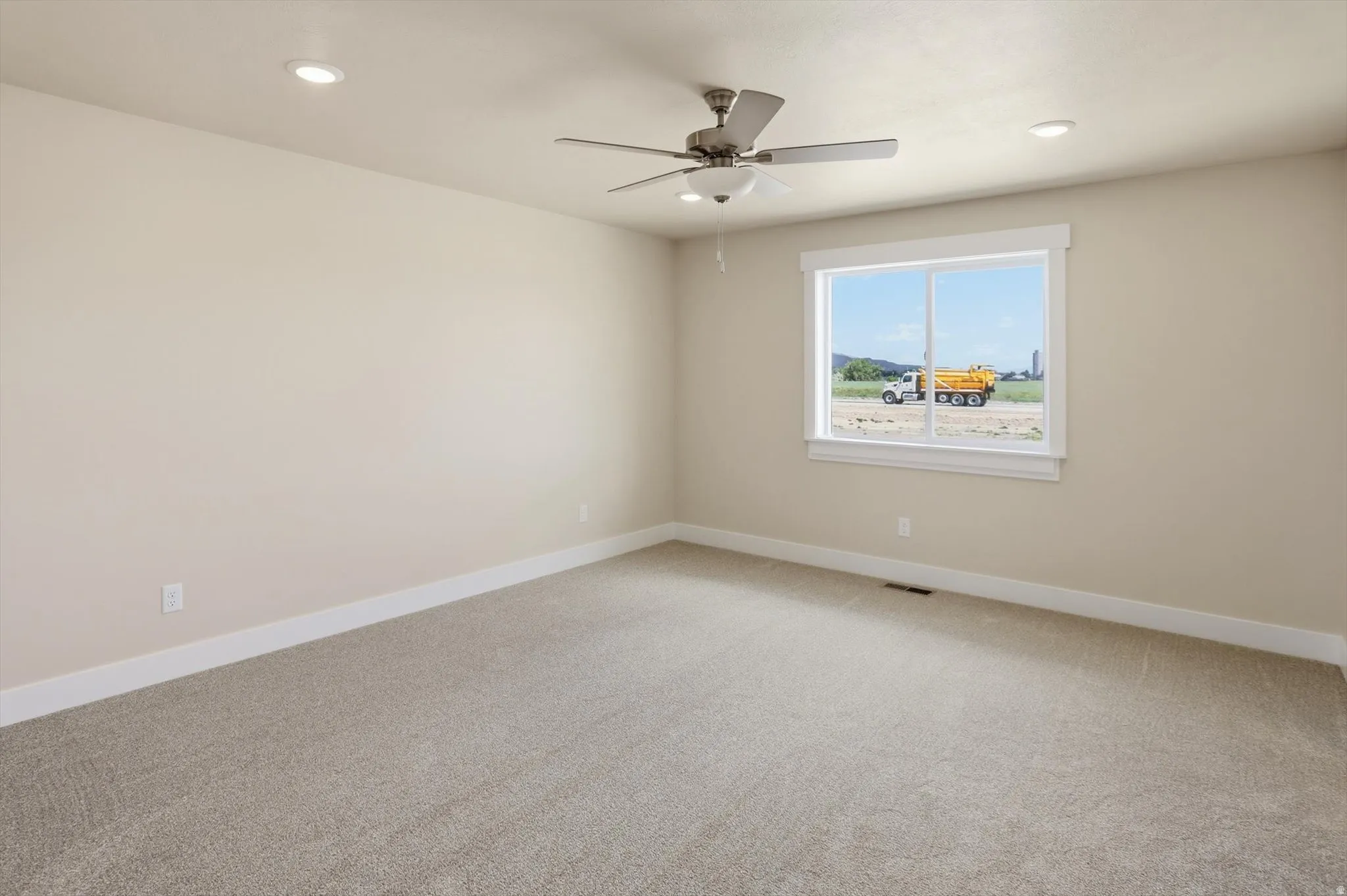 Carpeted interior with light beige walls and a white trim baseboard
