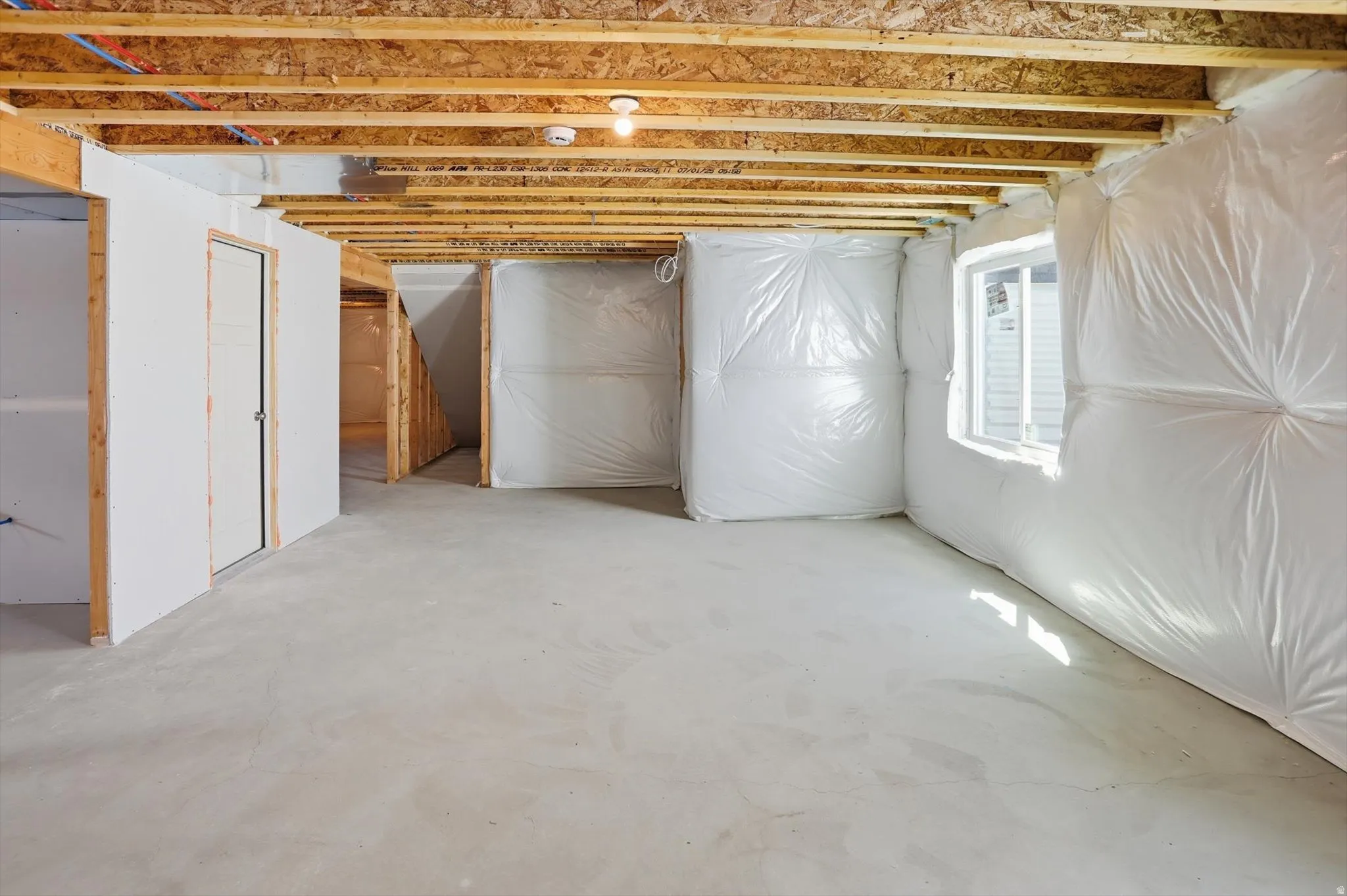 Unfinished basement featuring exposed wood joists and subfloor
