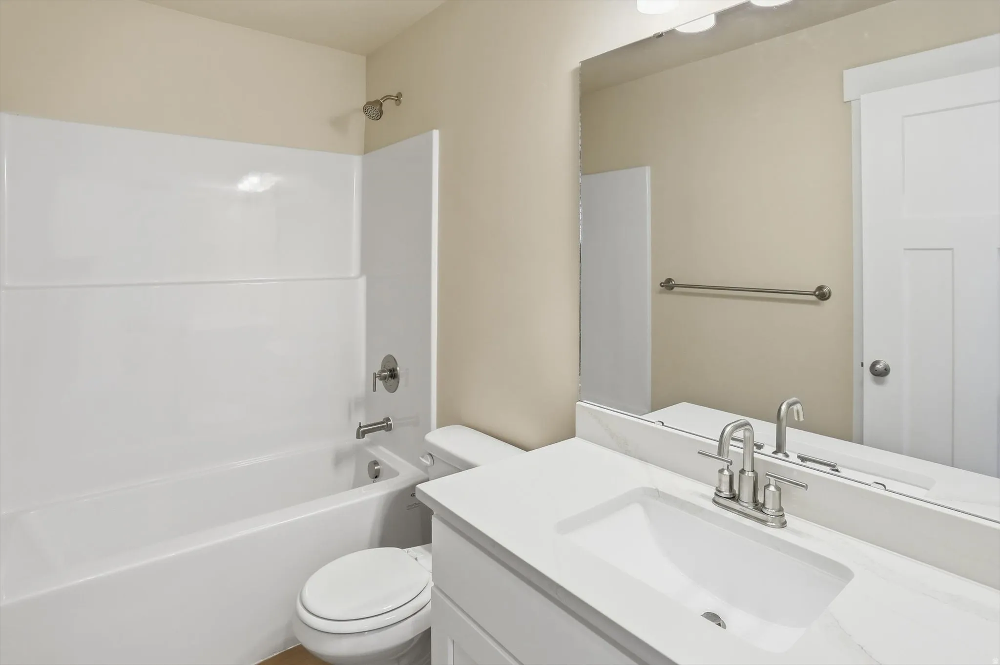 Bathroom featuring a white vanity with an integrated sink, brushed nickel faucet, and a large mirror