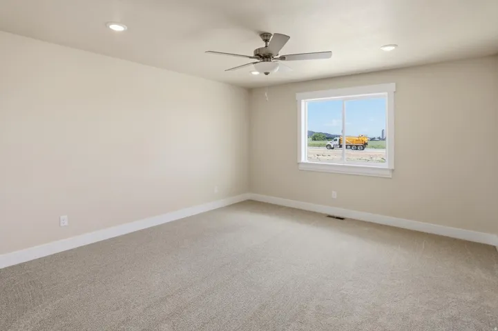 Carpeted interior with light beige walls and a white trim baseboard