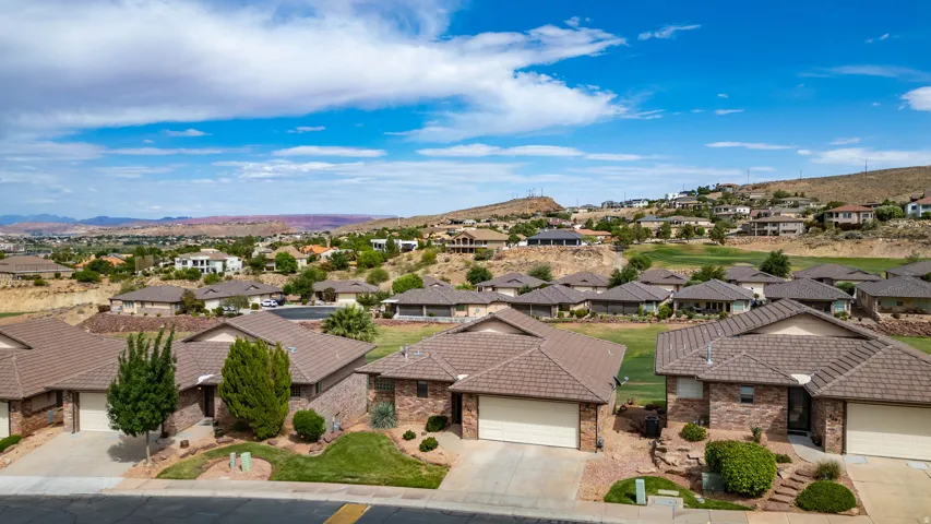 Residential community featuring single-story homes with brick facades and attached garages