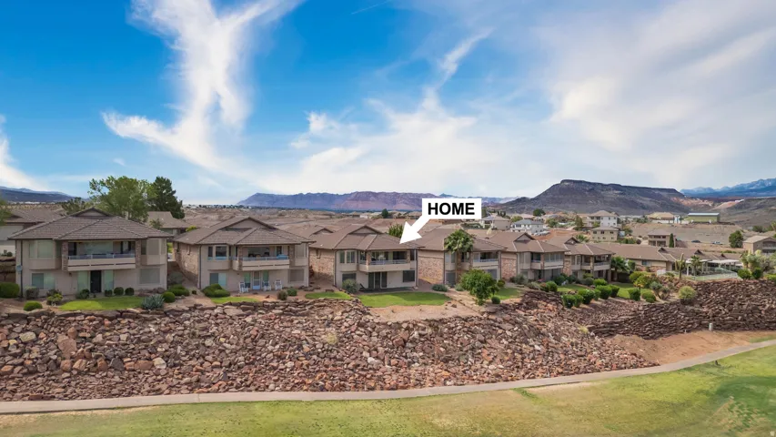 Terraced dwelling featuring a private balcony, ground-level patio, and surrounding desert landscaping with mountain scenery
