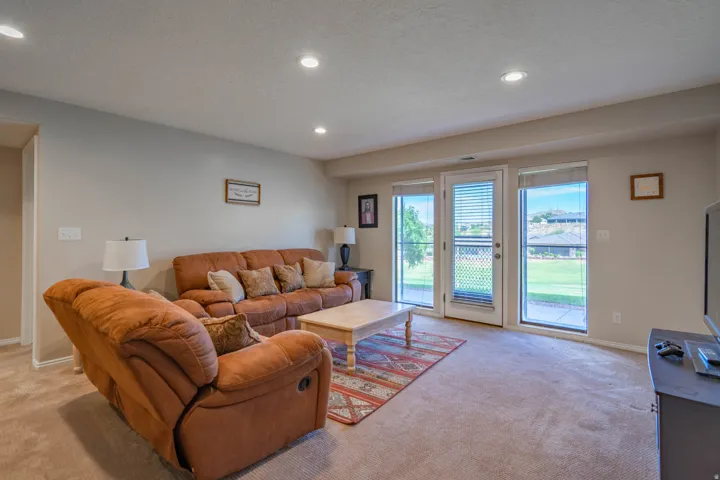 Carpeted downstairs living area featuring recessed lighting, light-toned walls, and a glass-paneled door with two side windows. Walkout basement with door to back yard, covered patio and Golf Course VIEWS
