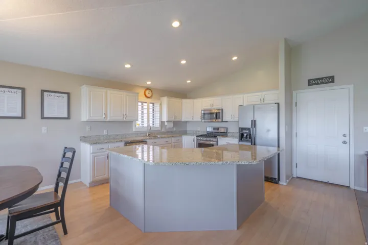 Spacious kitchen featuring white cabinetry, light-toned countertops, and stainless steel appliances