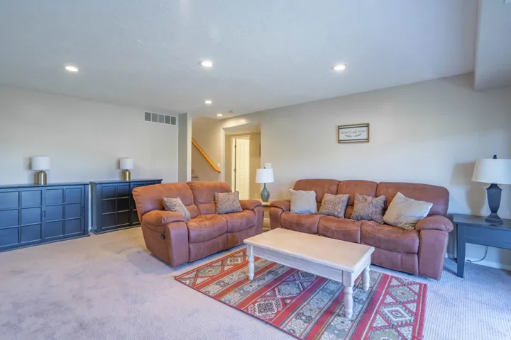 Spacious downstairs living area featuring neutral-toned carpeting and recessed lighting