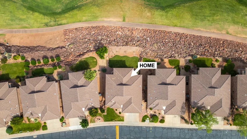 Aerial perspective of the property, featuring a pitched shingle roof and a landscaped rear yard
