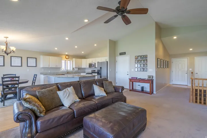 Open concept living area featuring a vaulted ceiling with a ceiling fan, recessed lighting, and light-tone walls