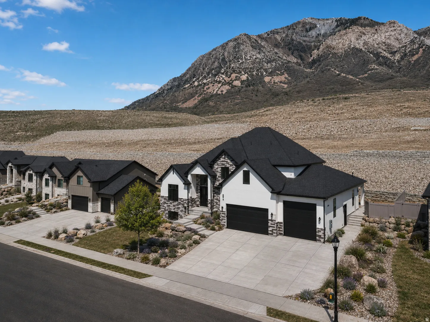 Contemporary two-story residence with a black shingle roof and white stucco siding