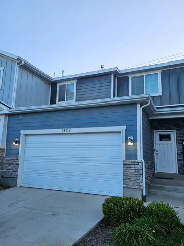 Two-story exterior featuring blue horizontal siding and stone veneer accents