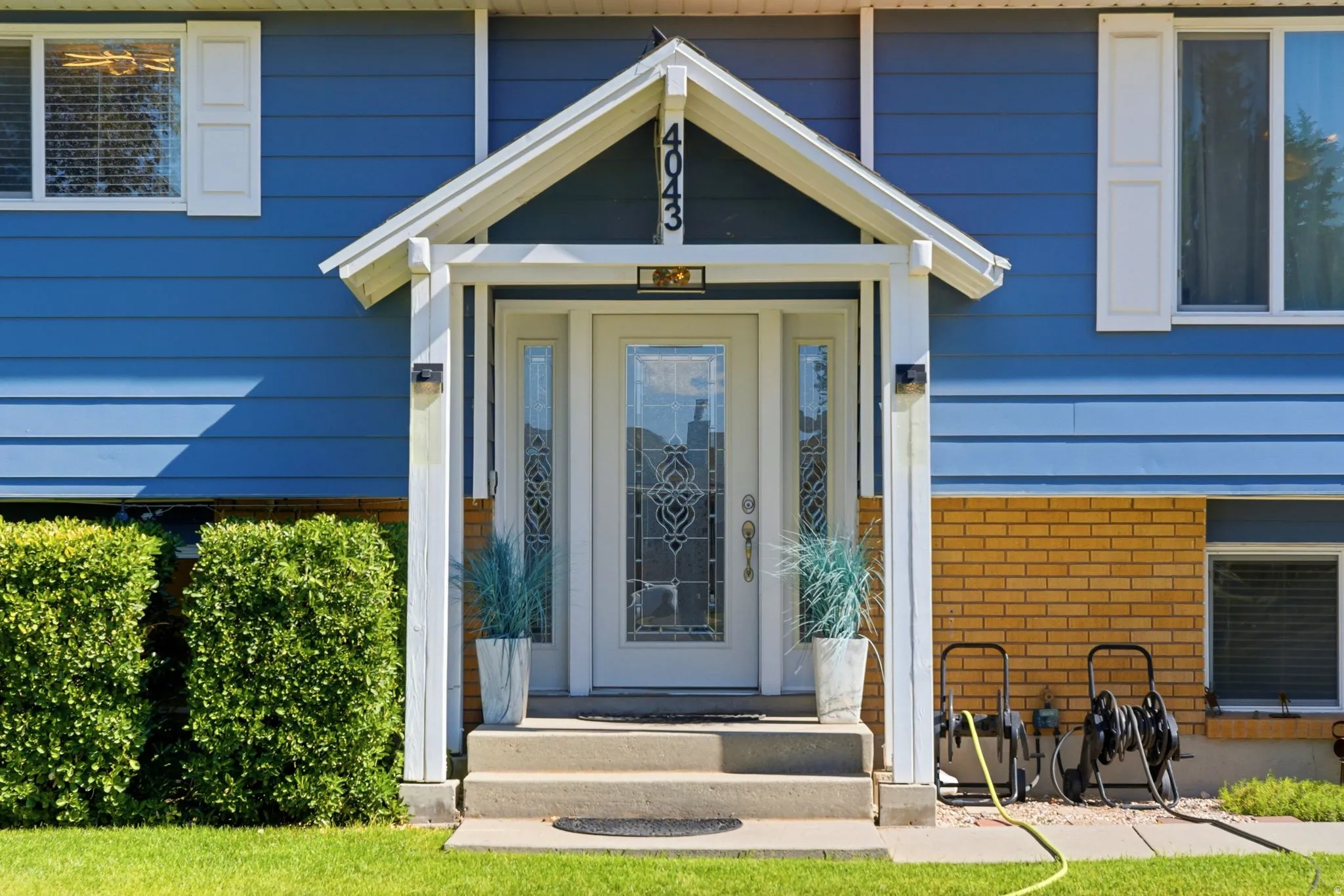 Inviting front entry featuring a decorative glass door, covered porch, and concrete steps