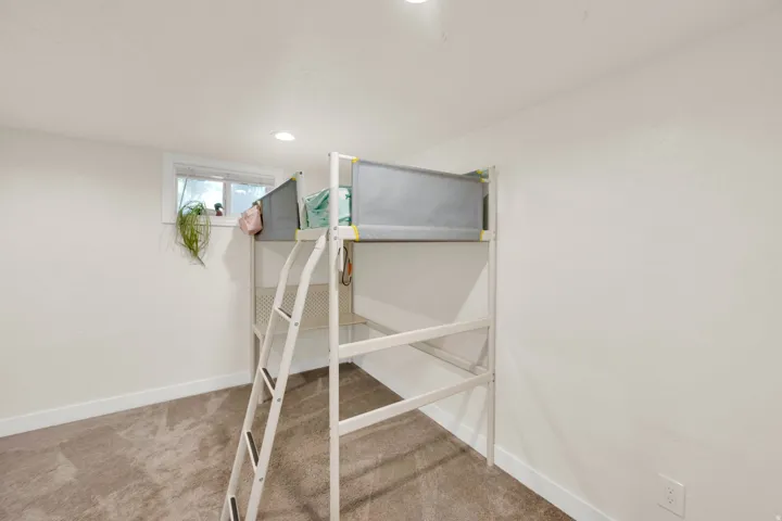 Carpeted room with recessed lighting and a window featuring white trim