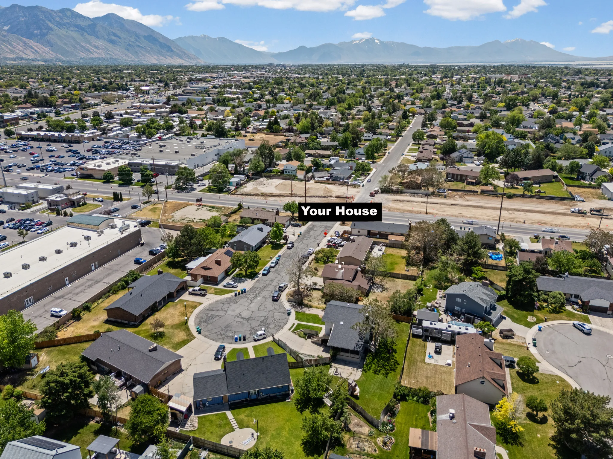Residential neighborhood with varied architectural styles under a mountainous backdrop