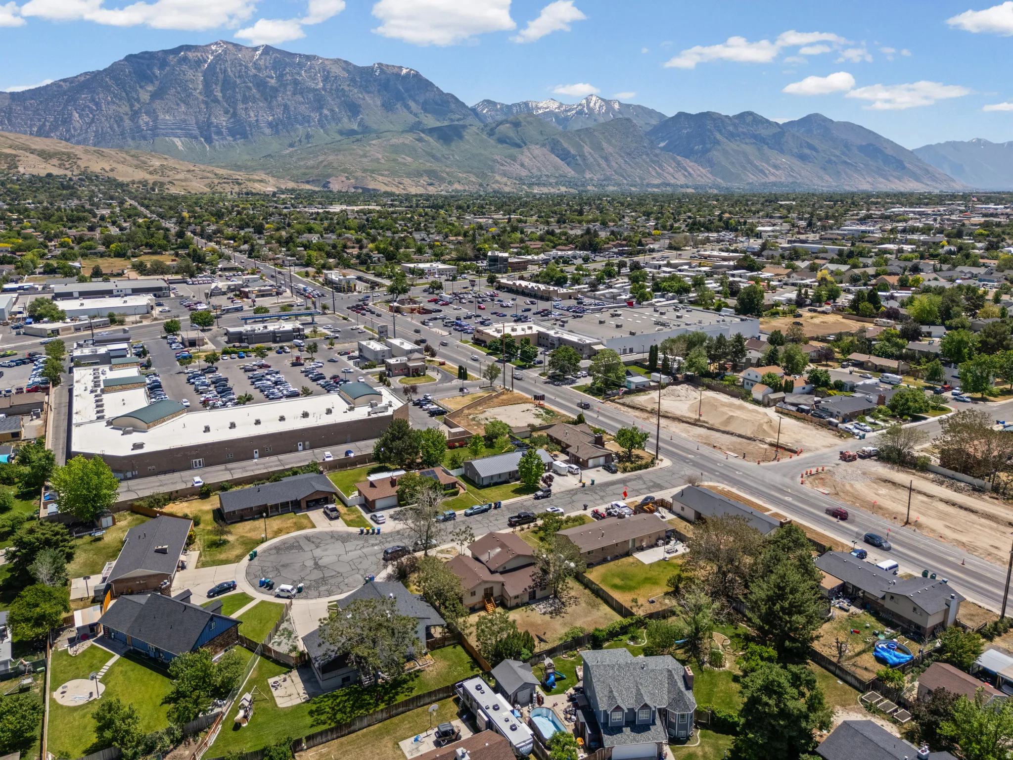 Expansive urban landscape featuring a commercial district, residential areas, and mountain backdrop