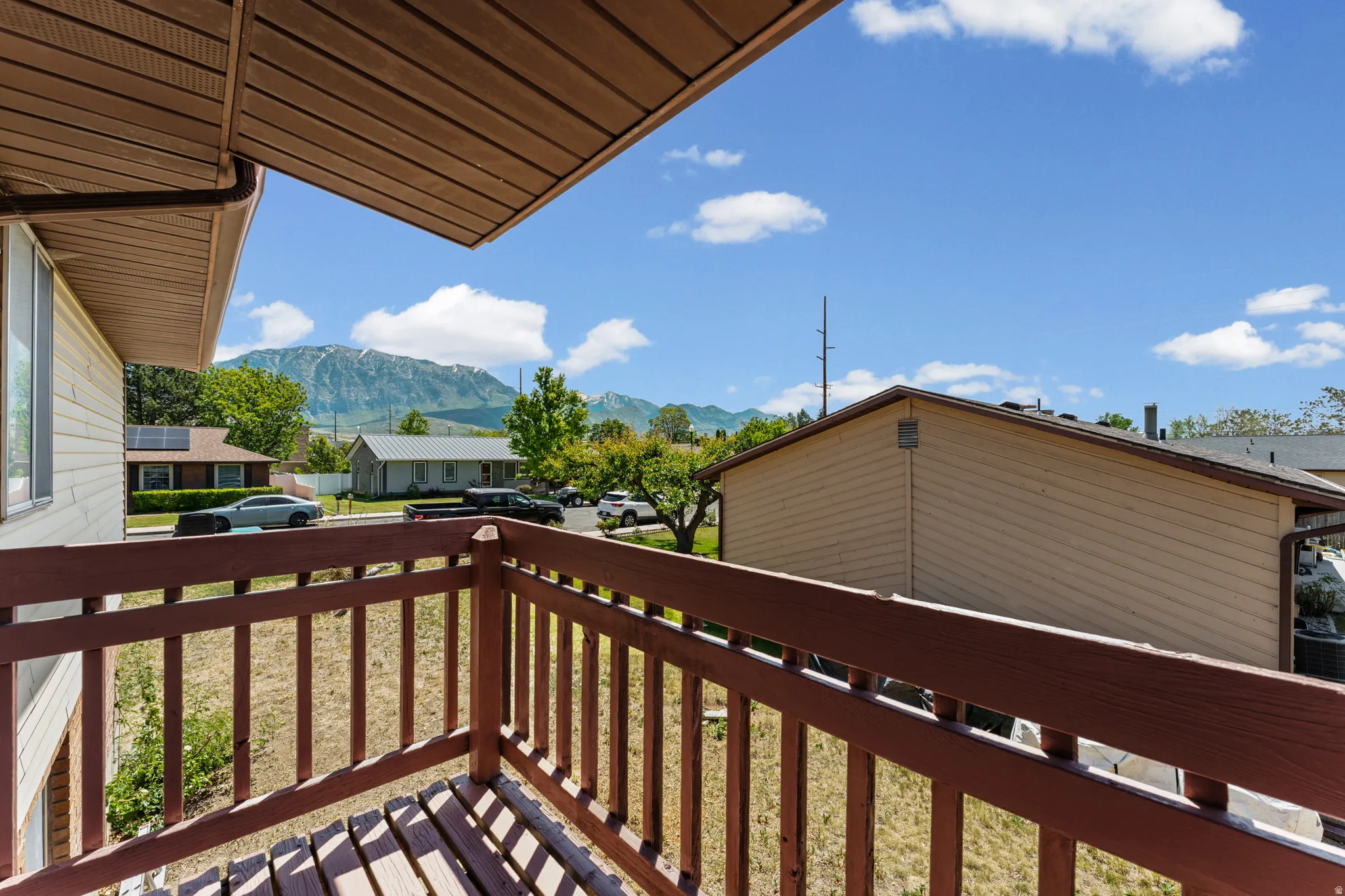 Balcony featuring a wood plank floor and matching wood railing