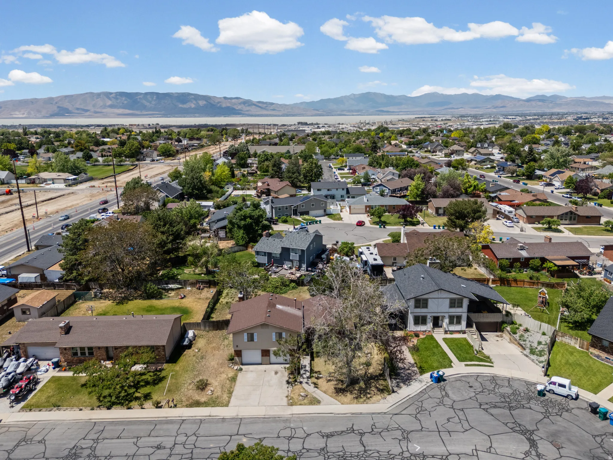 Aerial perspective highlighting a residential community with distant mountain ranges and a body of water