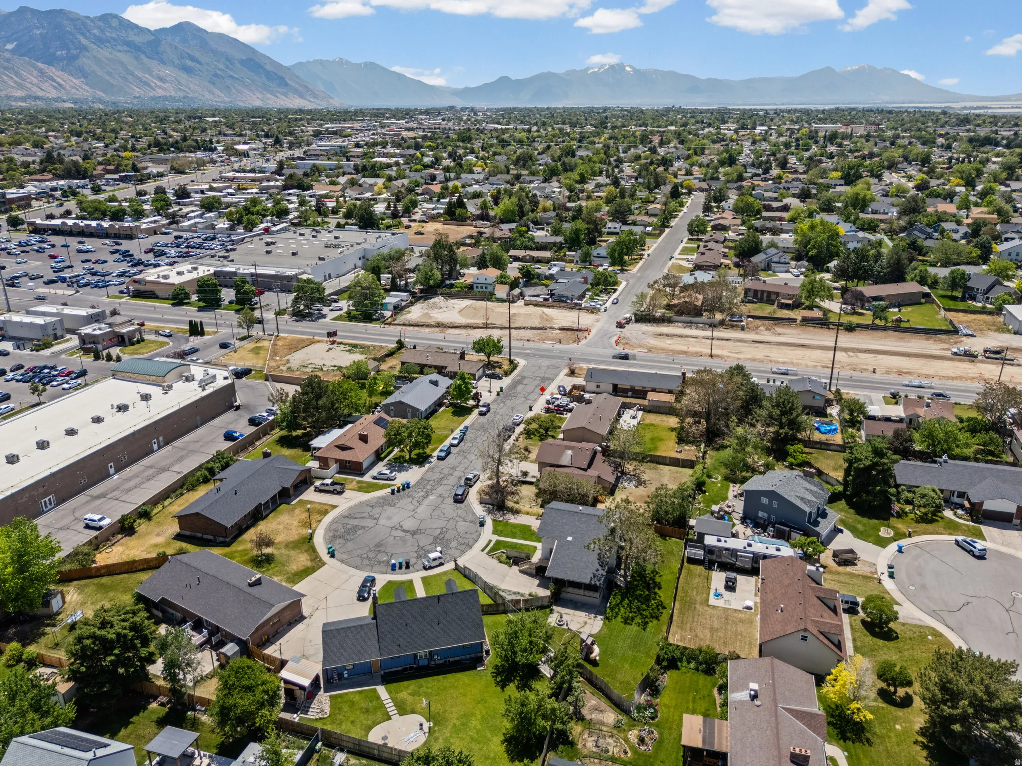 Expansive aerial perspective showcasing a residential neighborhood with surrounding commercial establishments
