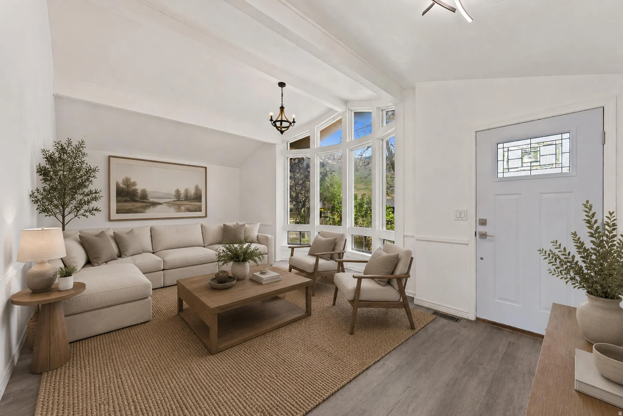Living area featuring a vaulted ceiling with exposed beams, wood-finish flooring, and a decorative front door with leaded glass
