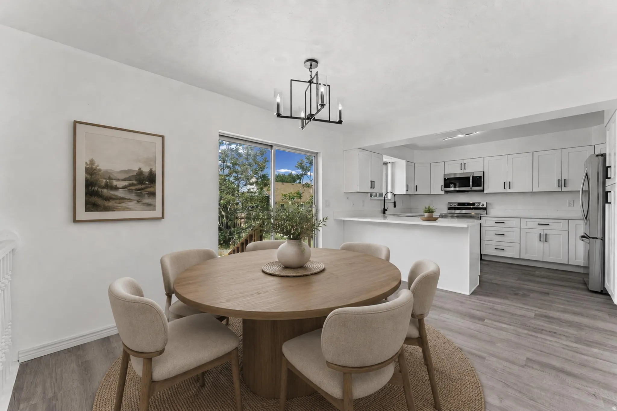 Dining area featuring wood-finish flooring and a contemporary chandelier