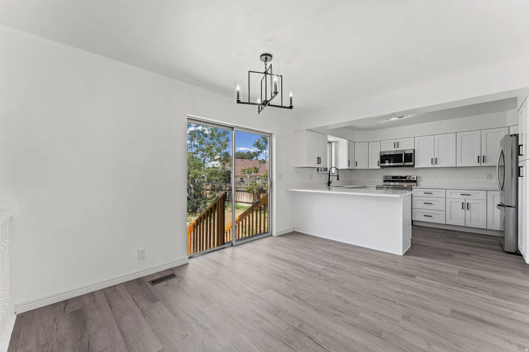 Open-concept kitchen and dining area featuring light wood-finish flooring