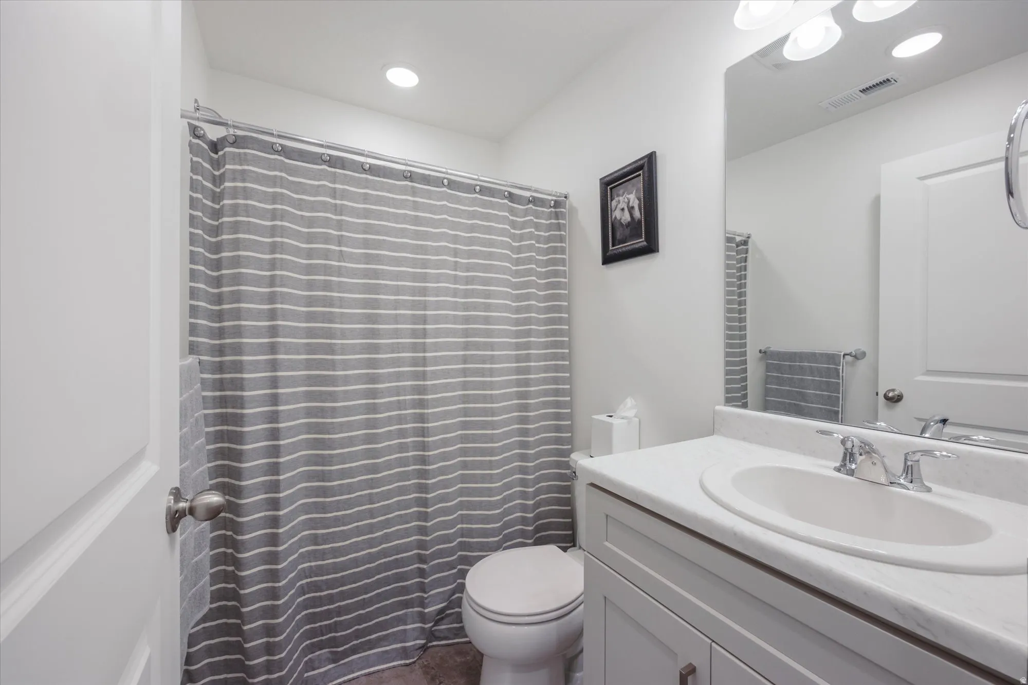 Bathroom featuring a shower-tub combination, single vanity with integrated sink, chrome faucet, and recessed ceiling lighting
