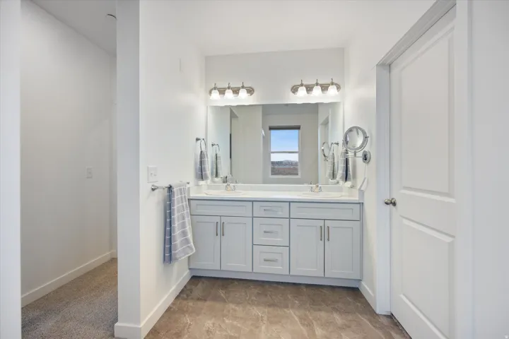 Double vanity with light gray shaker cabinetry, white countertops, and dual undermount sinks