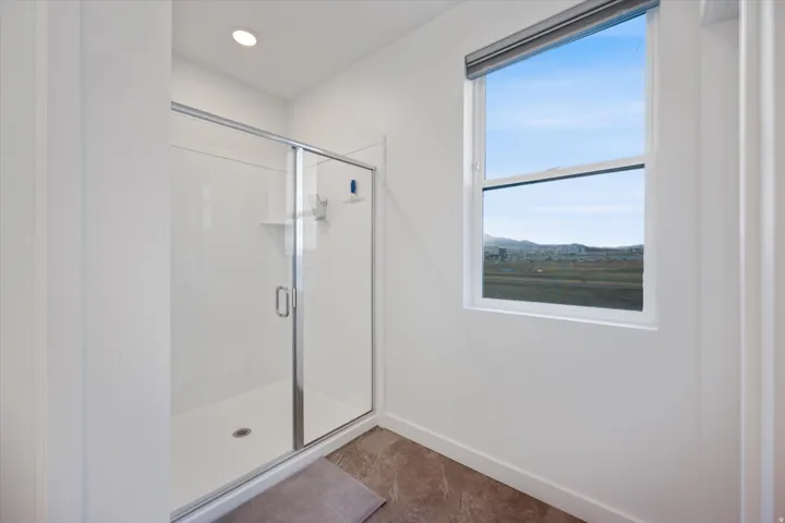 Shower enclosure with sliding glass doors and a white basin