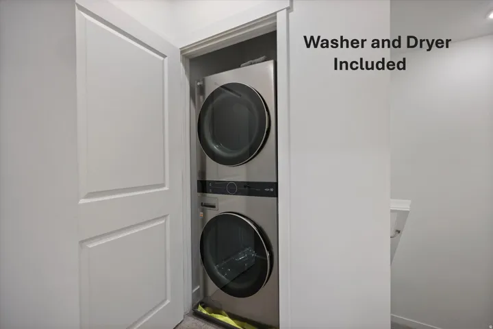 Stacked stainless steel washer and dryer units in a dedicated closet