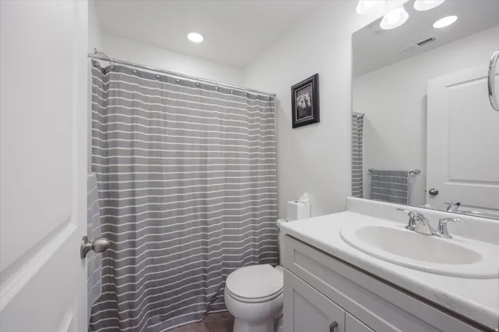 Bathroom featuring a shower-tub combination, single vanity with integrated sink, chrome faucet, and recessed ceiling lighting