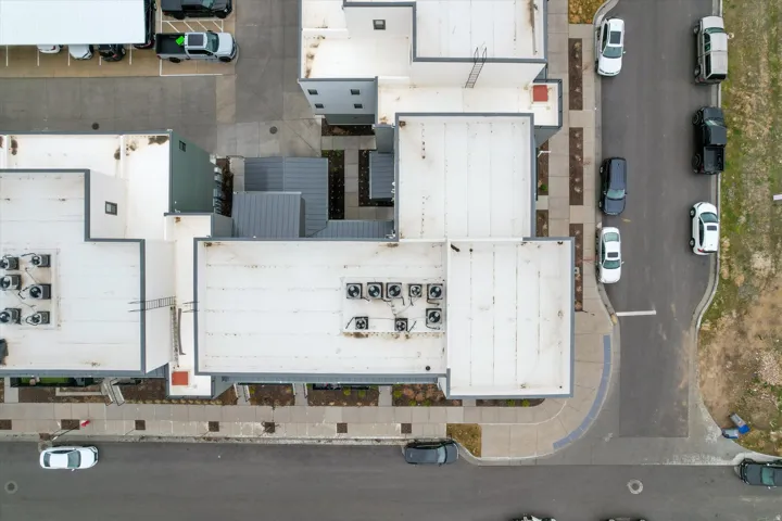Modern commercial building with a flat roof design, multiple rooftop HVAC units, and pedestrian walkways