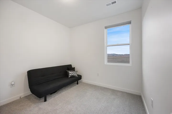 Neutral interior space featuring light gray carpeting and white painted walls