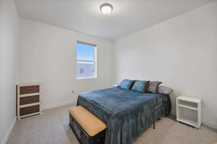 Spacious room featuring neutral carpeting, white walls, a single window, and a flush-mount ceiling light fixture
